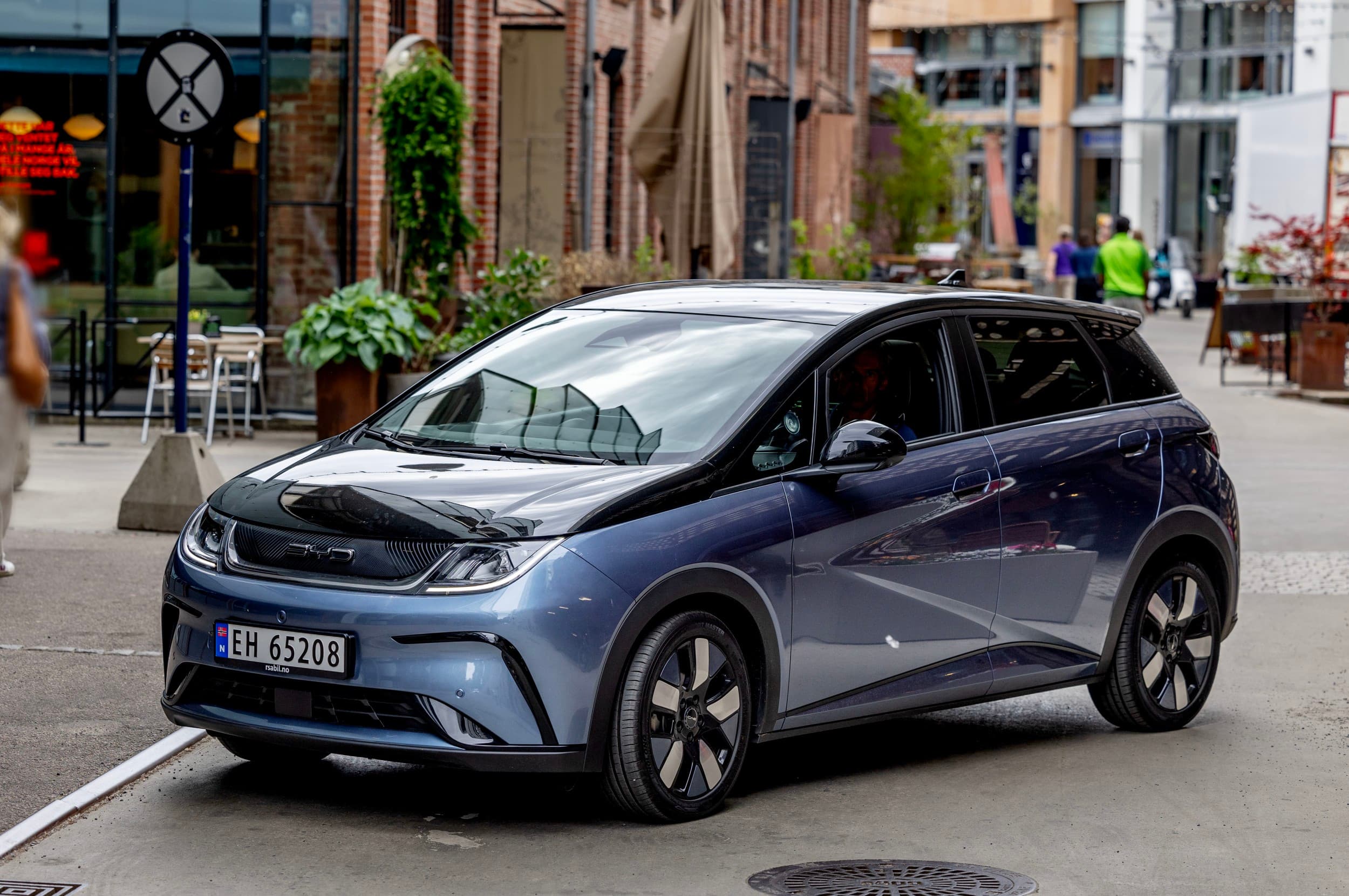 Svart og blå bil foran murbygg i elbiltest