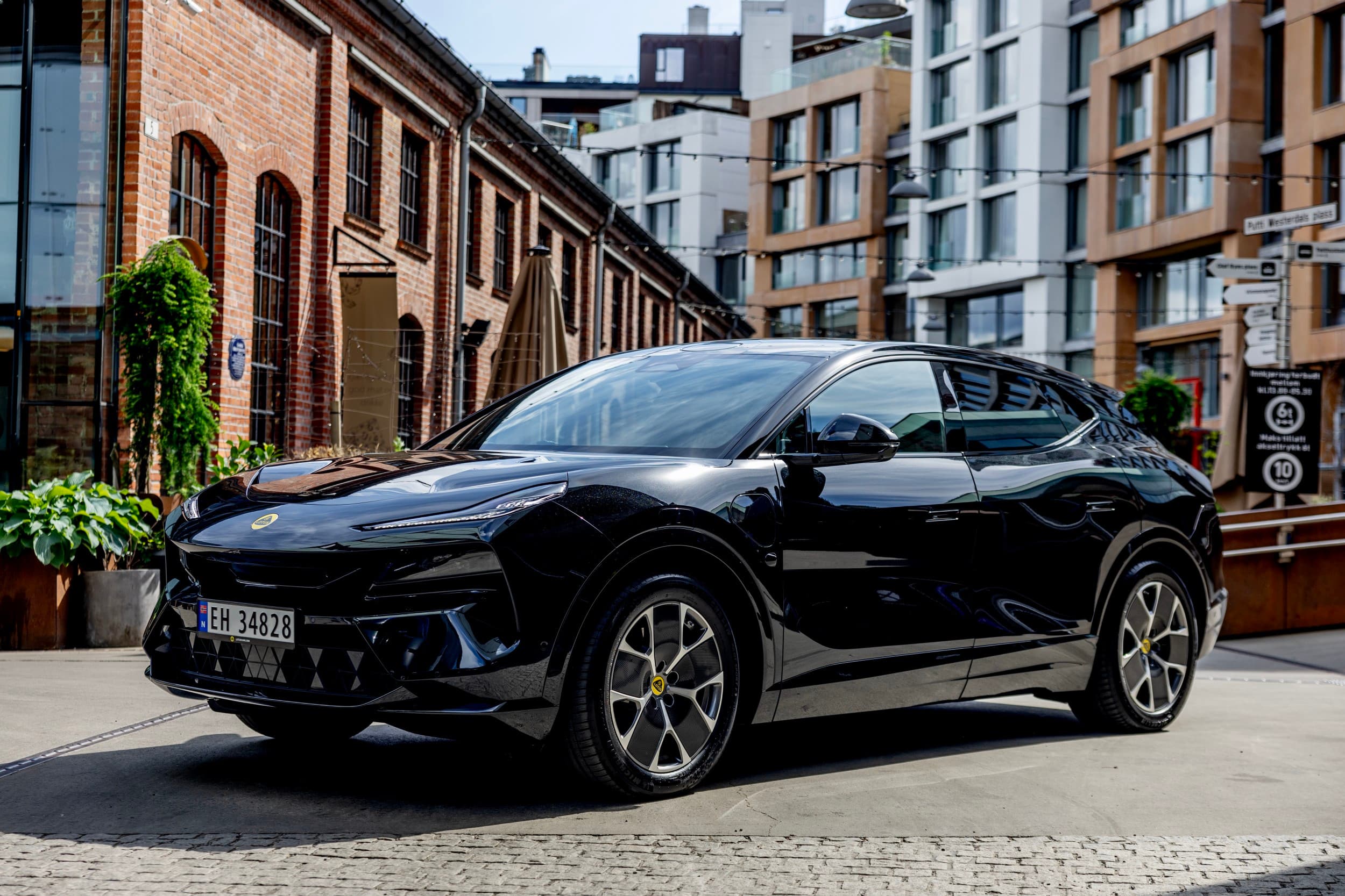 Mørk bil foran murbygg i elbiltest