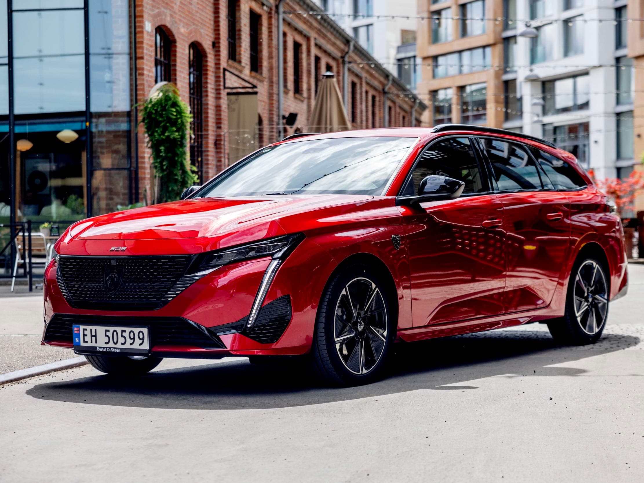 Rød bil foran murbygg i elbiltest