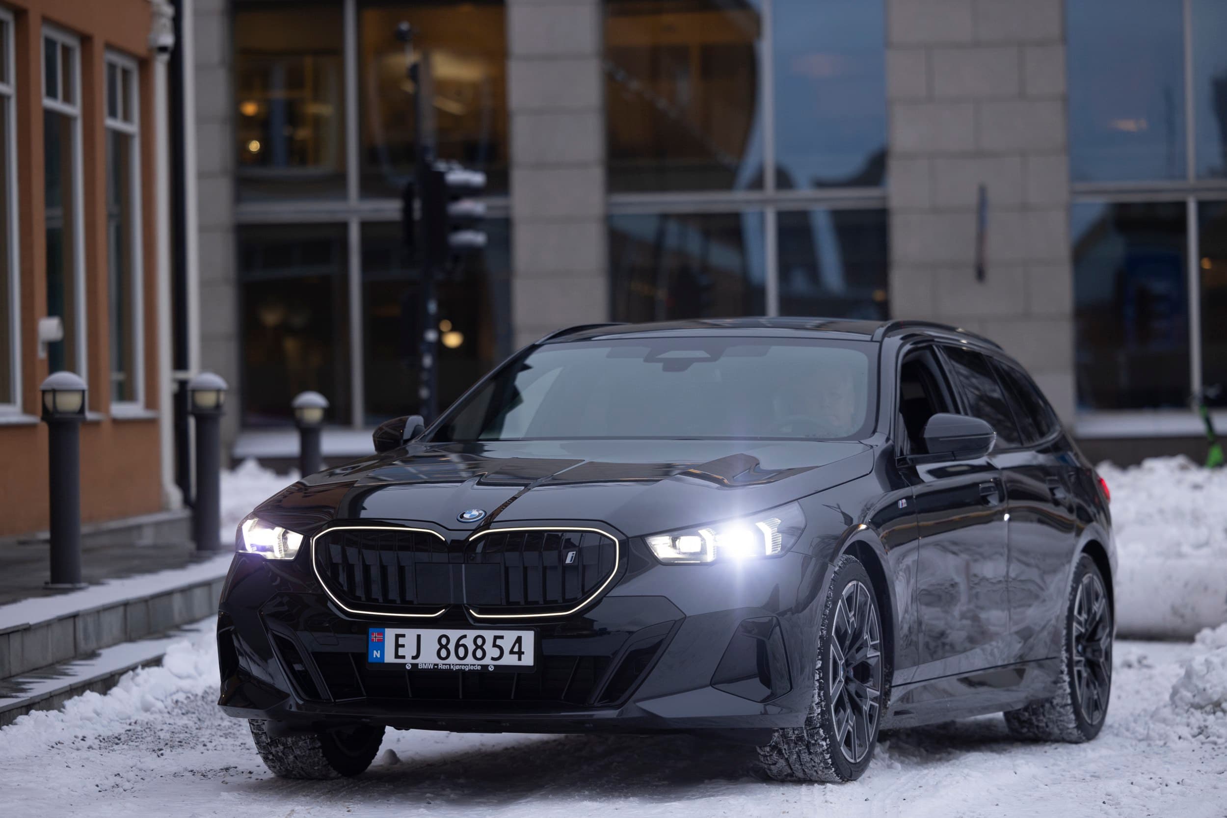 Svart bil utenfor et bygg