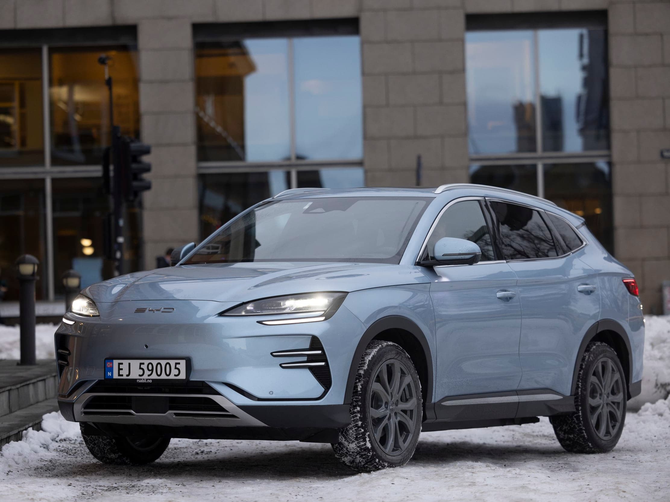 Lyseblå bil utenfor et bygg