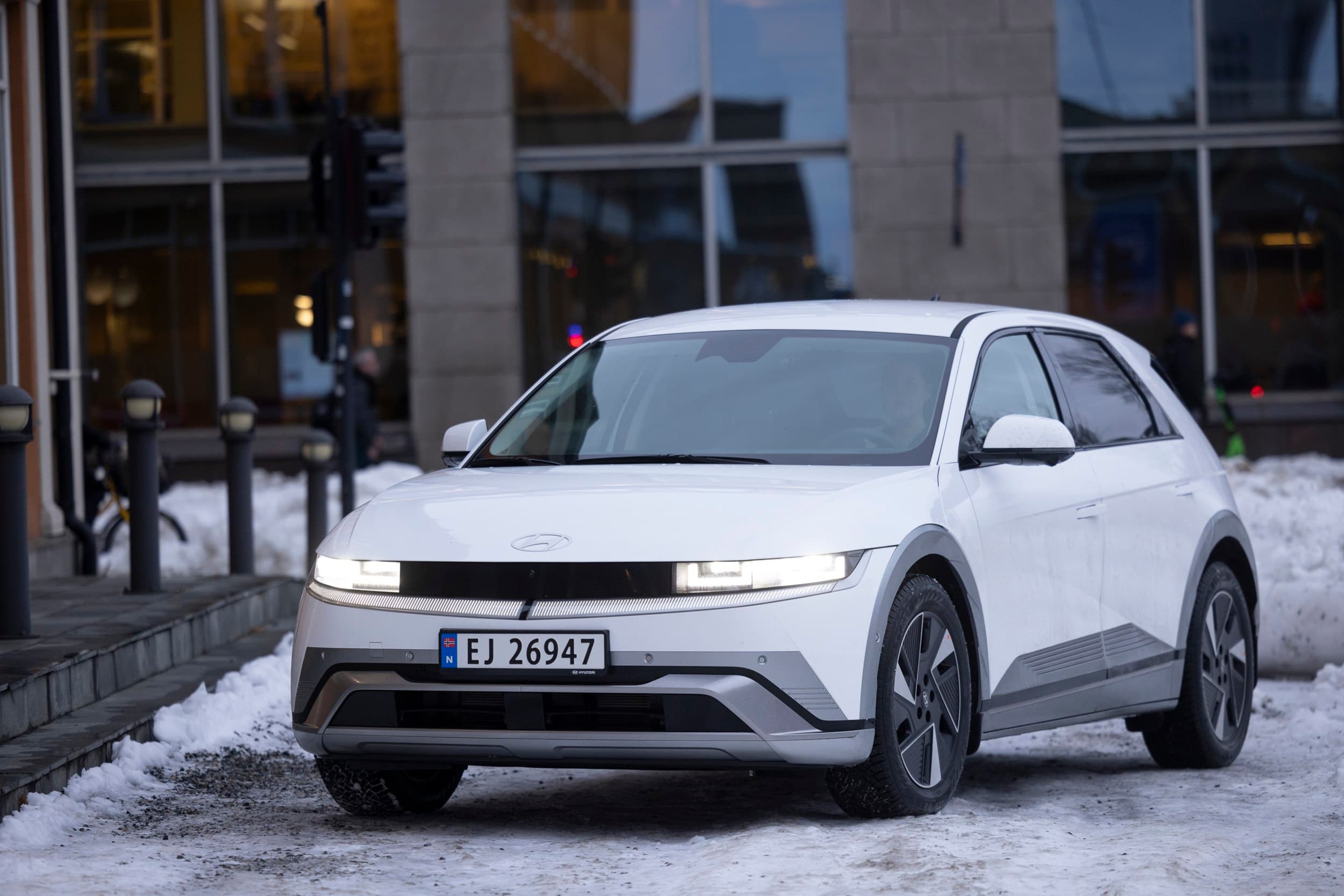 Hvit bil foran bygning