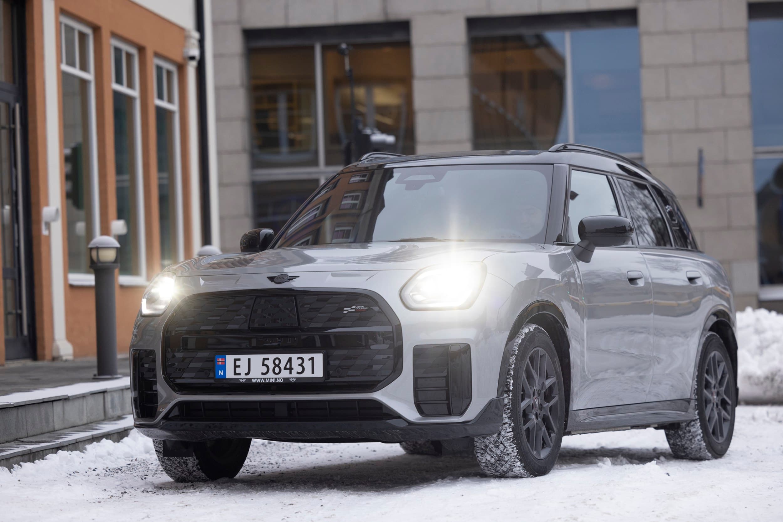 Grå bil utenfor et bygg