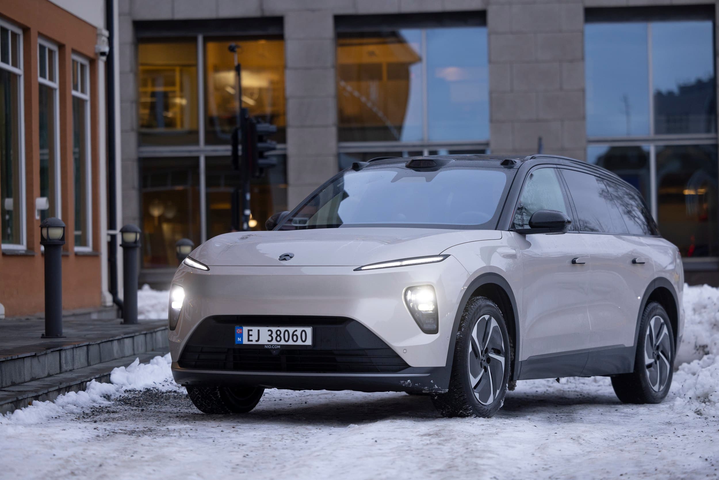 Lys bil utenfor et bygg