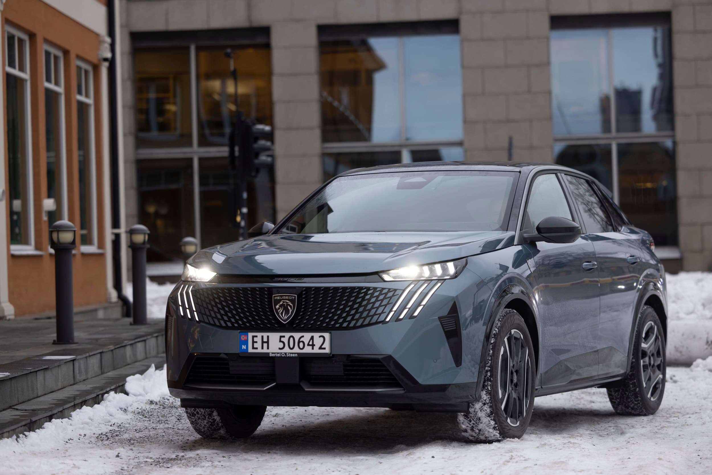 Blå bil utenfor et bygg