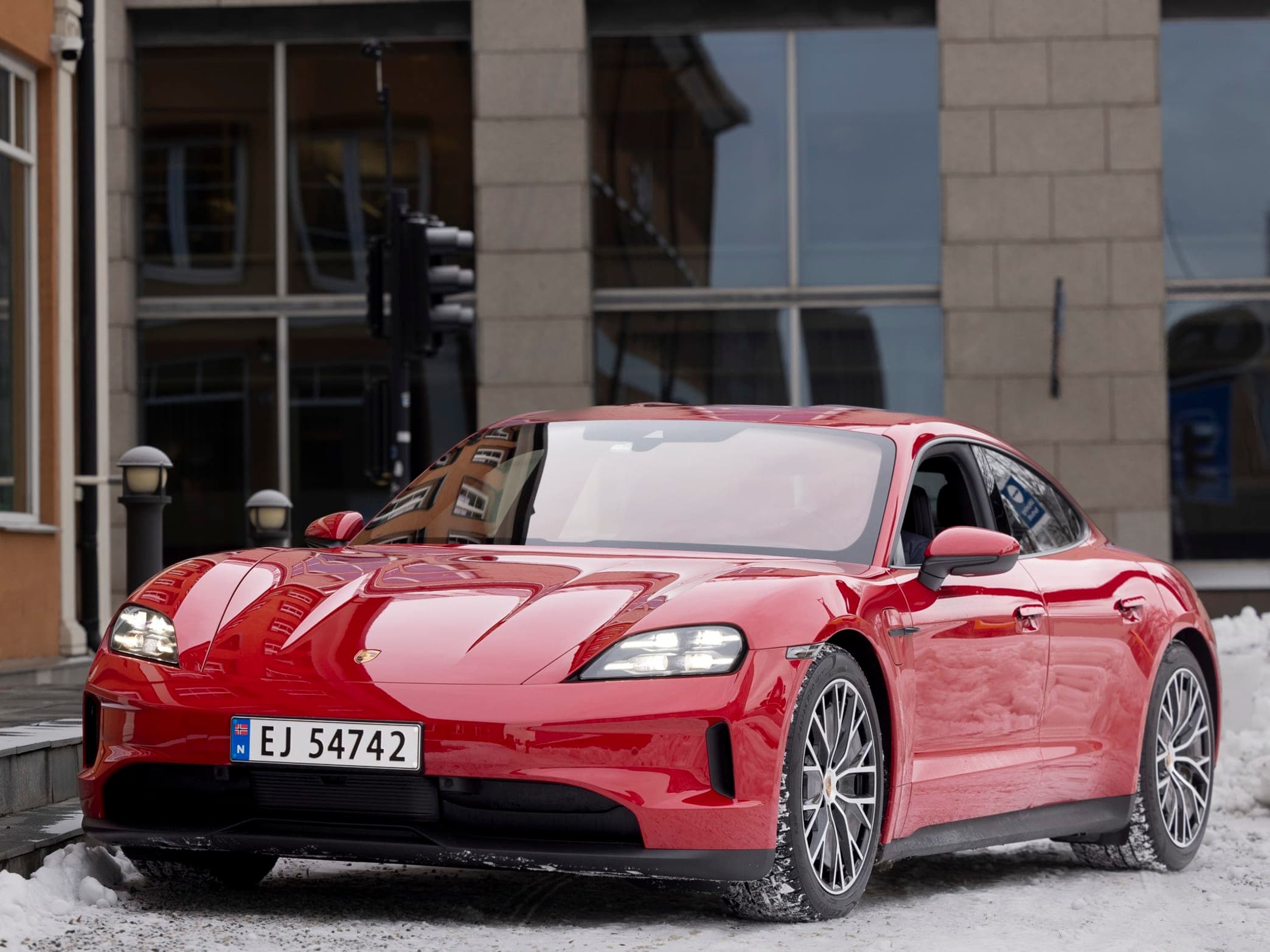 Rød bil utenfor et bygg