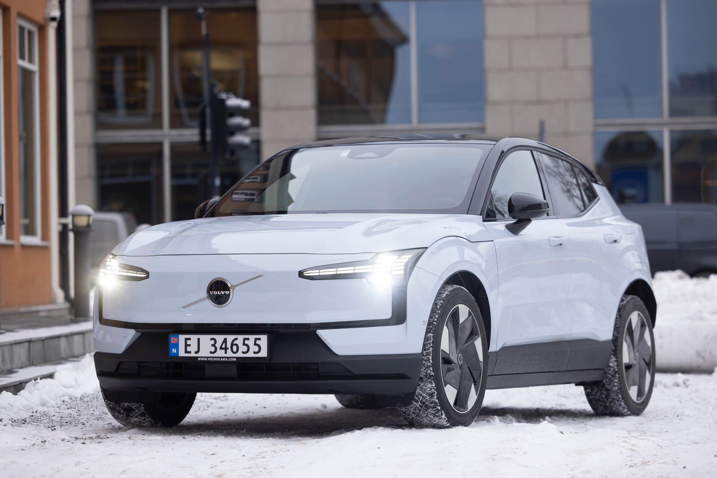 Hvit bil utenfor et bygg