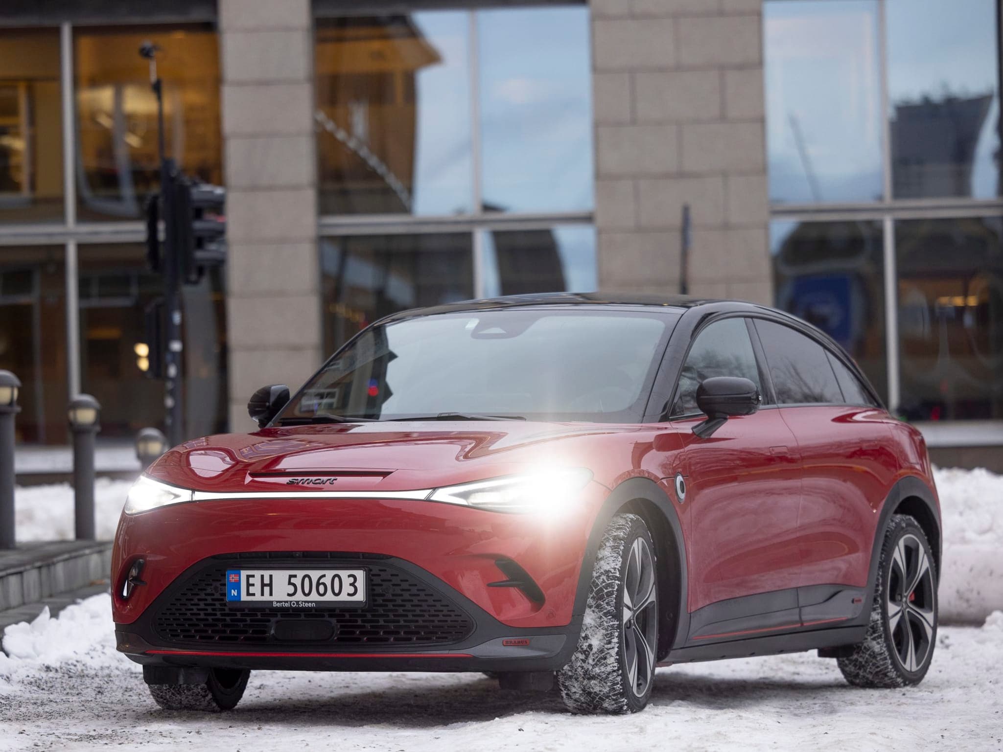 Rød bil utenfor et bygg